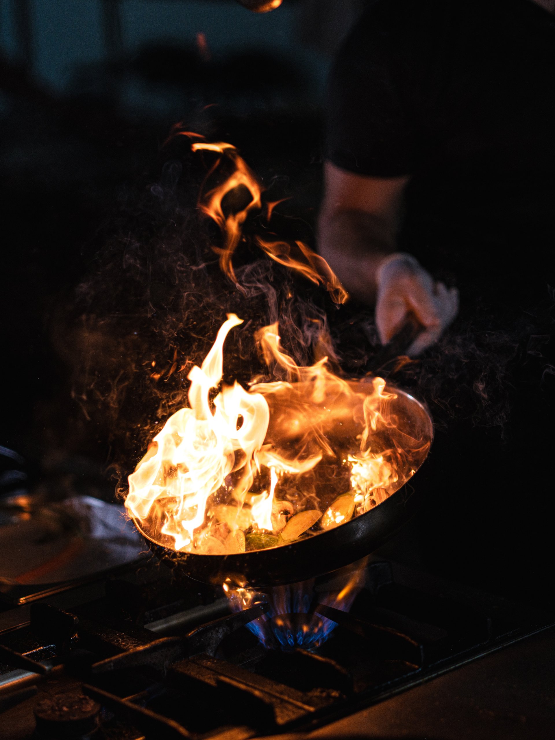 Close-up of flames coming from a frying pan while cooking in a restaurant kitchen