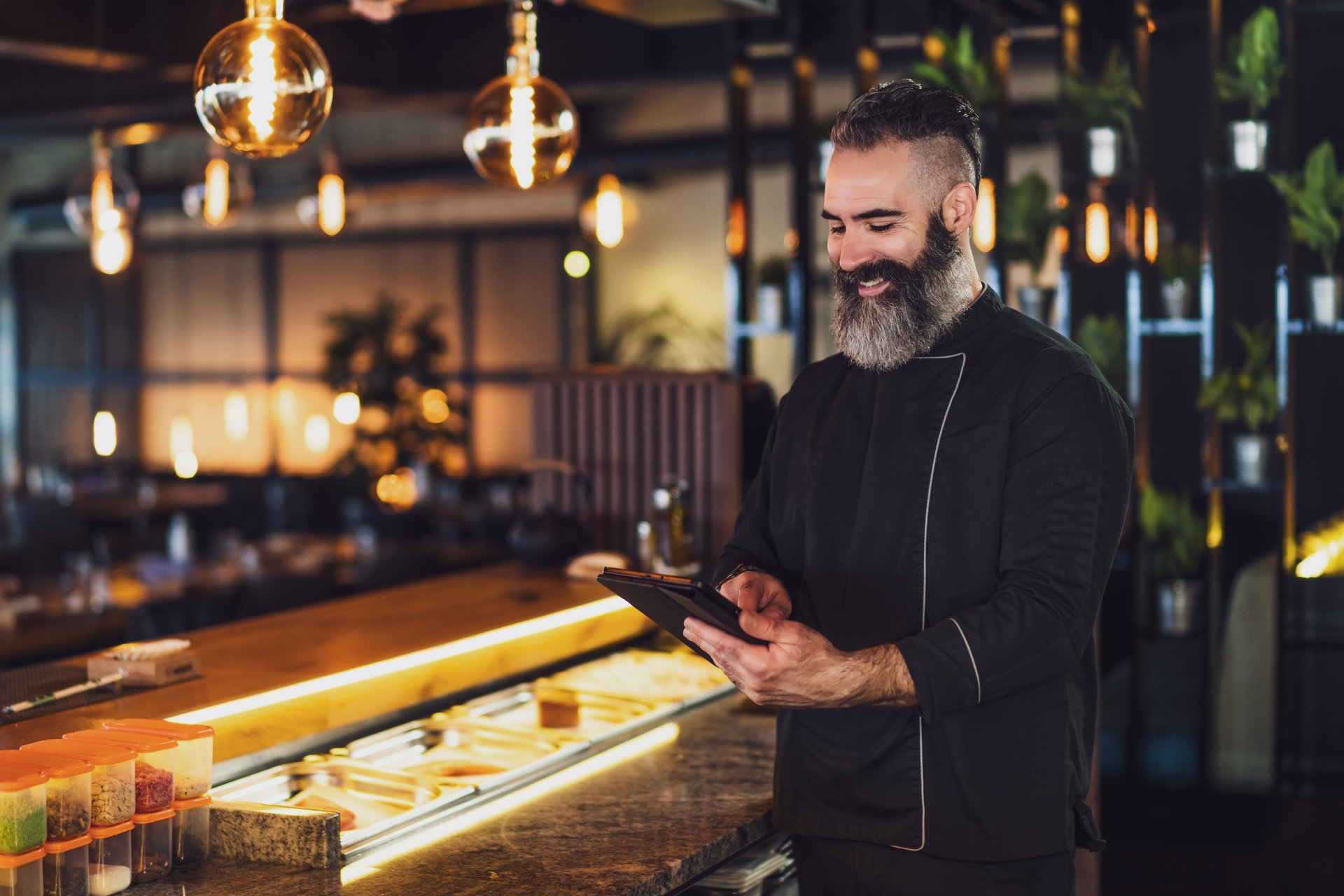 Restaurant staff member using digital procurement technology on a tablet