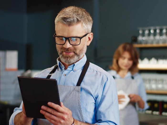 Restaurant staff member using a tablet to place a digital order.