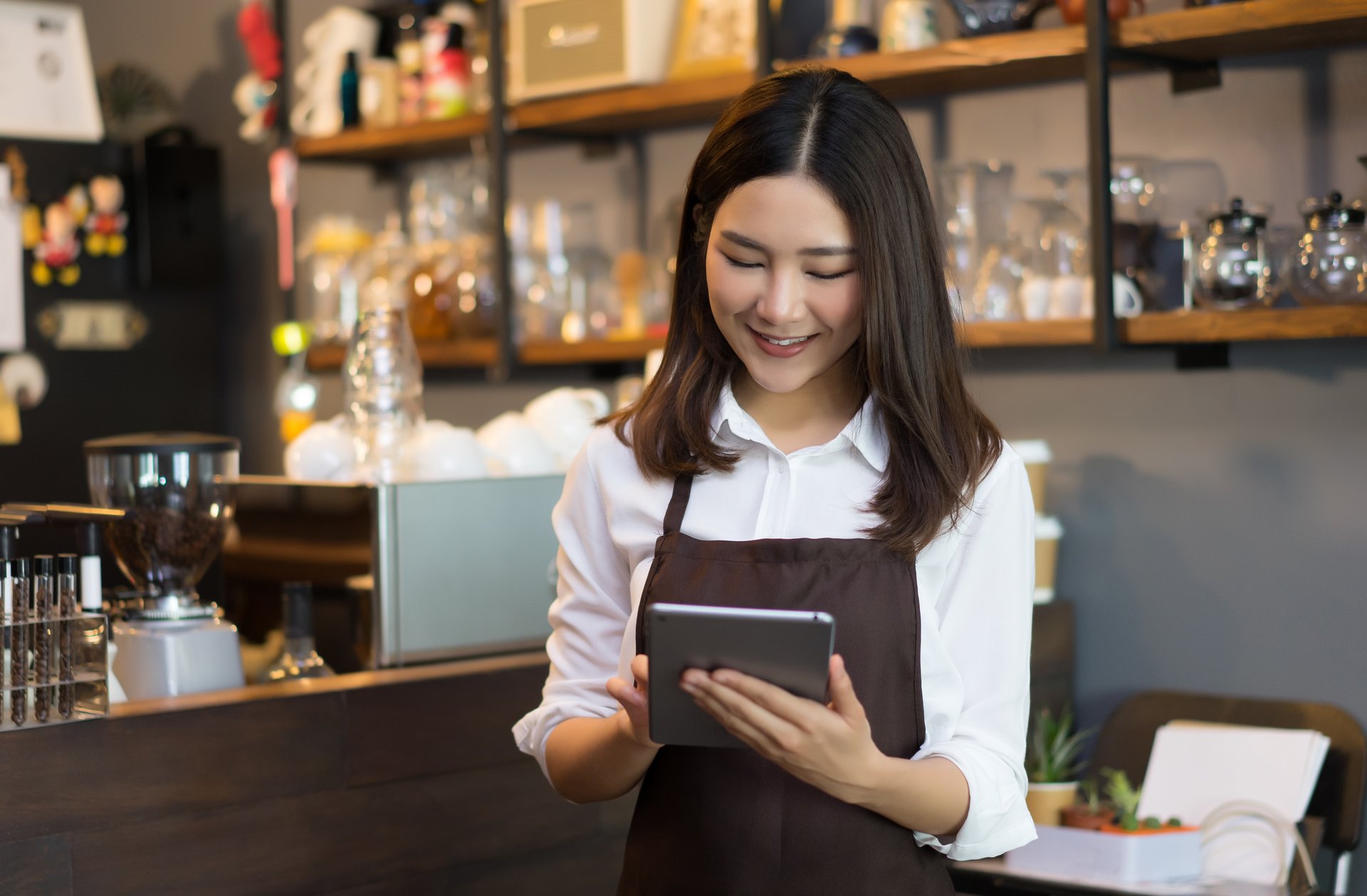 Staff member in cafe using a tablet for digital ordering