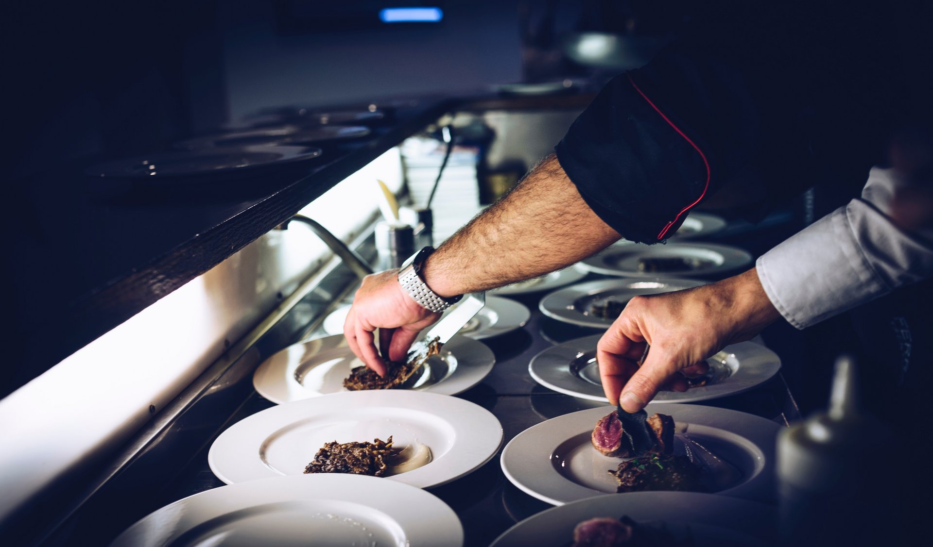 Close-up of chefs plating dishes in a restaurant kitchen