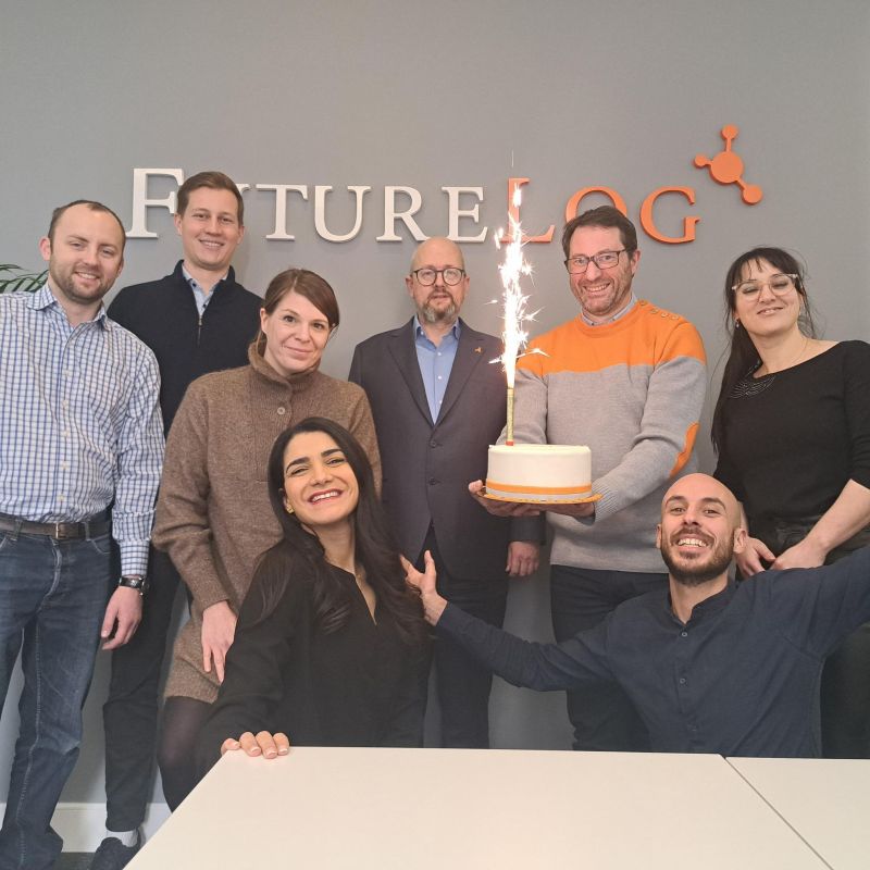 Team members from FutureLog France standing in a group and holding a birthday cake