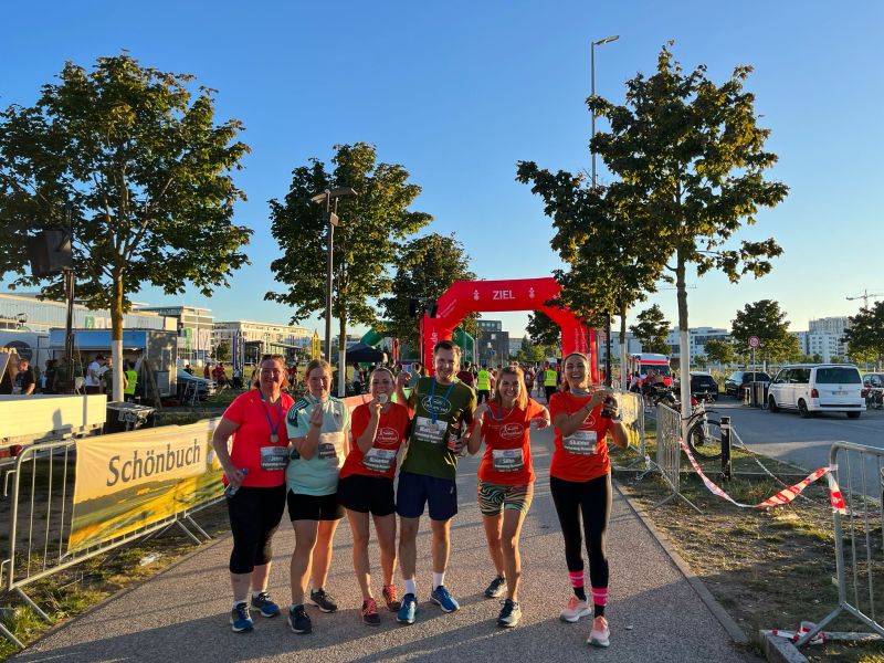 FutureLog team members dressed in running clothes preparing for their outdoor charity run, with the starting line in the background